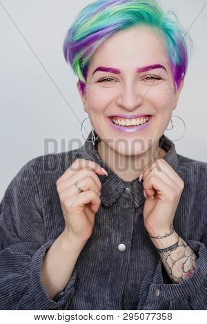 A Young Woman With Short Hair, A Pixie Bob Haircut, Different Colored Hair, Blue, Green, Violet.