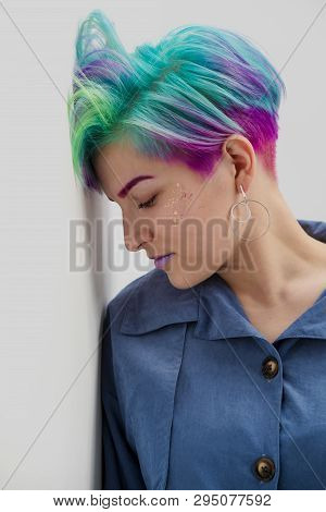 A Young Woman With Short Hair, A Pixie Bob Haircut, Different Colored Hair, Blue, Green, Violet.