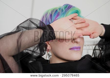 A Young Woman With Short Hair, A Pixie Bob Haircut, Different Colored Hair, Blue, Green, Violet.