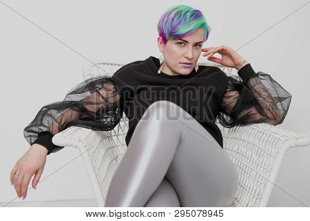 A Young Woman With Short Hair, A Pixie Bob Haircut, Different Colored Hair, Blue, Green, Violet.