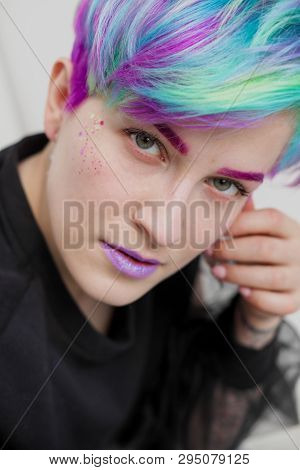 A Young Woman With Short Hair, A Pixie Bob Haircut, Different Colored Hair, Blue, Green, Violet.