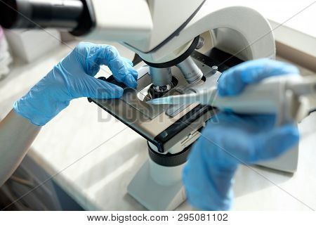 Woman Laborant Working With Microscope Holding Automatic Pipette