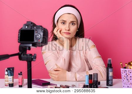Close Up Portrait Of Young Thoughtfull Woman Sits In Front Of Camera, Has Upsetexpression, Surrounde