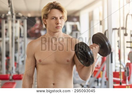 Closeup Portrait Of Athletic Strong Guy Holding Heavy Dumbbell In One Hand, Having Gimlet Eyes, Doin