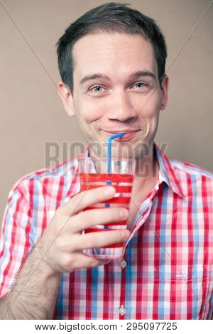 Happy Thoughtful Blue-eyed Hipster Boy Drinking Over Wooden Background