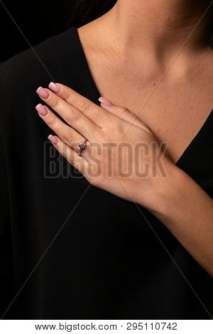 Womens Silver Diamond Ring In The Shape Of A Square With A Fringe On Finger, On A Black Background.