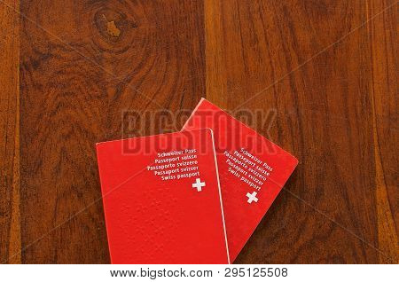 Top View Of Two Swiss Passports On A Wooden Table