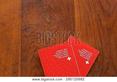 Top View Of Two Swiss Passports On A Wooden Table
