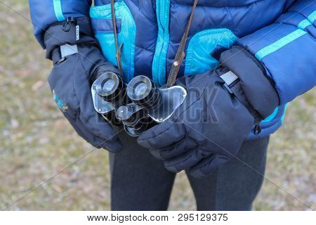The Boy In Blue Jacket Holds Binoculars