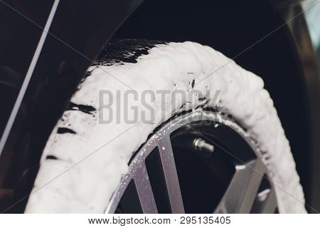 Car Care Or Car Detailing Process. Using Black Sponge To Washing The Tire. Blacker Rubber.