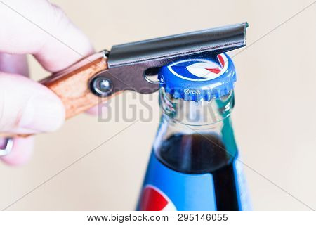 Moscow, Russia - April 4, 2019: Opening A Cap Of Pepsi Glass Bottle By Bottle Opener Close Up. Pepsi