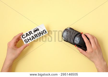 Car Sharing Concept. Human Hands Holding Toy Car Model And Text Sign 