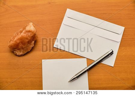 Paper, Modern Envelope, Paperweight And Metal Ballpoint On Wooden Table