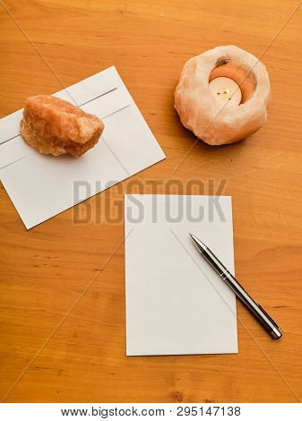 Paper, Modern Envelope, Paperweight, Candle And Metal Ballpoint On Wooden Table