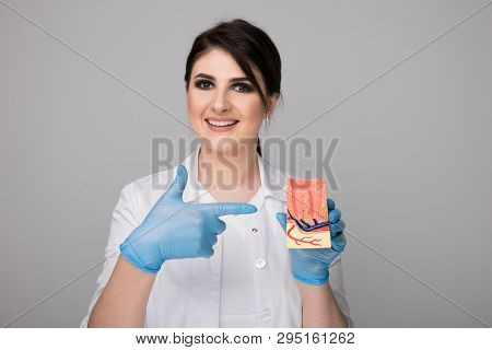 Female Dentist With Model Gingiva Isolated Over The Grey Background.
