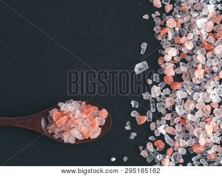 Himalayan Pink Salt In Spoon On Black Stone Background. Copy Space
