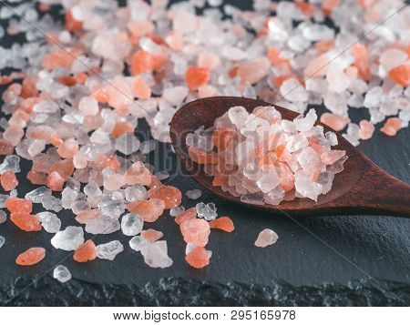 Himalayan Pink Salt In Spoon On Black Stone Background. Copy Space
