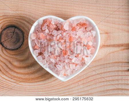 Himalayan Pink Salt In Hearth-shape Bowl On Wooden Background. Copy Space