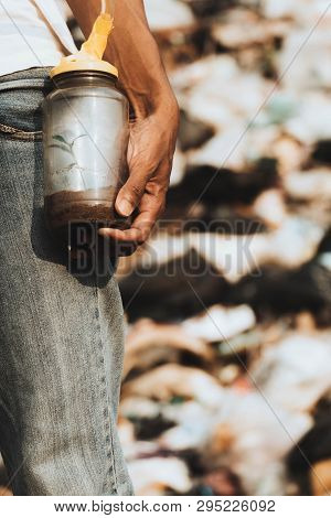 Glass Bottle In Hand With Trees Growing Inside A Glass Bottle To Create Oxygen. Concept For Save The