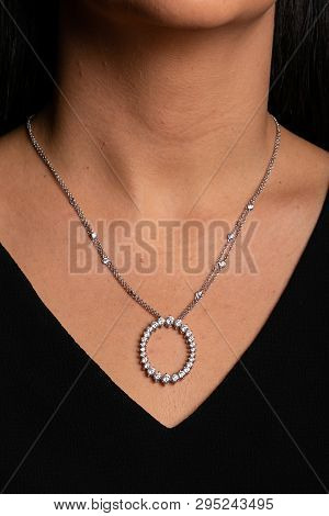 Silver Double Chain With Pendant In The Form Of Rings With Stones Around Hanging On Neck.