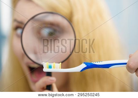 Beautiful Perfectionist Young Woman Checking Her Tooth Brush Through Manifying Loupe Glass. Hygiene,