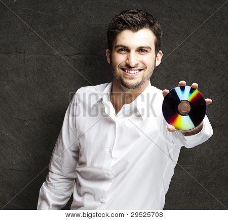 portret młodego człowieka posiadającego cd na czarnym tle