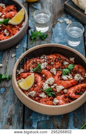 Shrimps Saganaki With Feta Cheese On A Plate On A Table