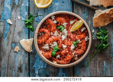 Shrimps Saganaki With Feta Cheese On A Plate On A Table