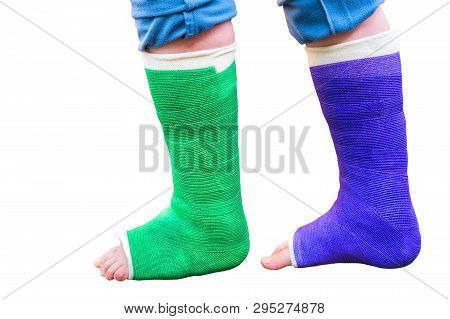 Teenage Boy Walks With Two Colorful Gypsum Legs Isolated On White Background