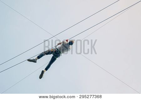Man Descend On A Zip Line. Adult Man Zip Line Adventure. Zipline Is An Exciting Adventure Activity.