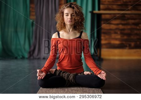 Yoga Girl Sitting In Lotus Pose Or Padmasana. Practicing On Mat