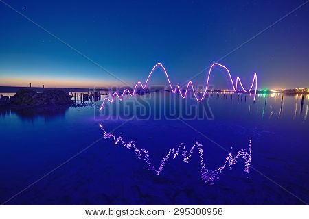 Amazing Laser Fireshow Performance In The Night Blue Sky With Reflections In The Sea Water
