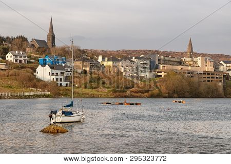 Boat In Clifden Bay With Village In Background