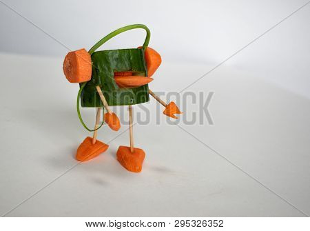 A Cheerful Man-a Cucumber Listening To Music On Headphones From The Carrots