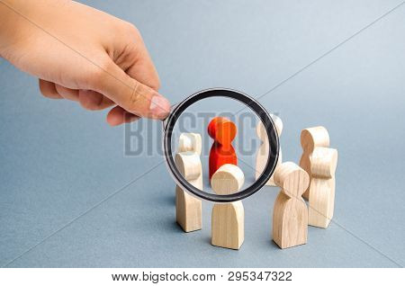 Magnifying Glass Is Looking At The People Stand In A Circle On A Gray Background. Communication. Bus