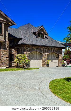 Fragment Of Luxury House With Double Garage And Concrete Driveway In Front. Front Yard Of Luxury Fam