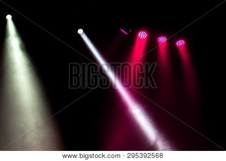 Stage Lights. Several Projectors In The Dark. Multi-colored Light Beams From The Stage Spotlights On