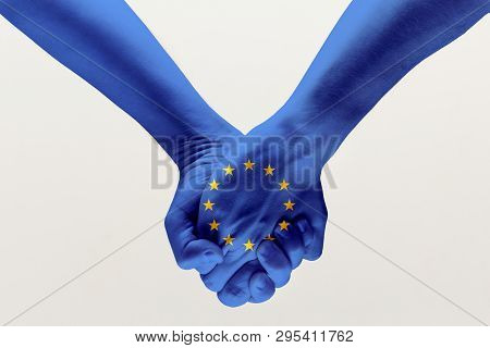 Peace And Strong. Male Hands Holding Colored In Blue Eu Flag Isolated On Gray Studio Background. Con