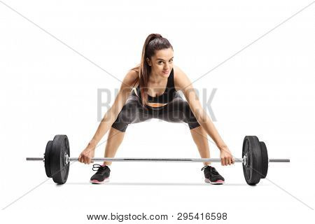 Young female athlete kneeling and lifting weigths isolated on white background