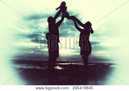 Little Family Silhouette Art. An Icon Of Mom And Daddy Lifting Their Children High Up, Enjoying Toge