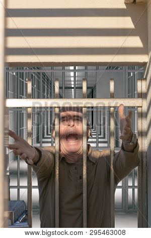 Man Reaching Out To Freedom From A Prison Door Screaming
