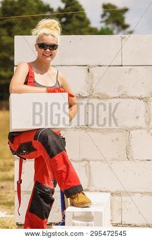 Strong Pretty Woman Working On Construction Site, Building House, Installing Gray Airbricks. Industr