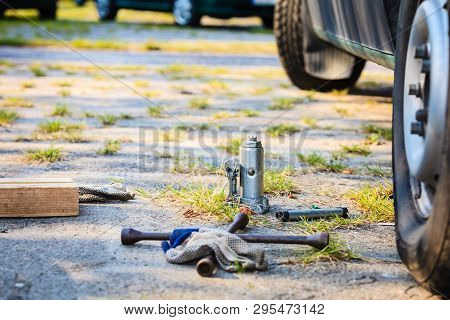 Manual Socket Wheel Wrench And Jack Lying On Ground. Tire Car Repair Objects Concept.