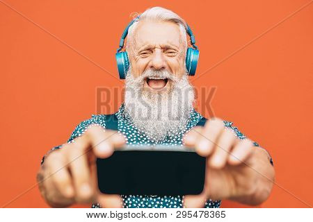 Senior Bearded Man Making Selfie With Mobile Phone While Listening To His Favorite Playlist With Hea