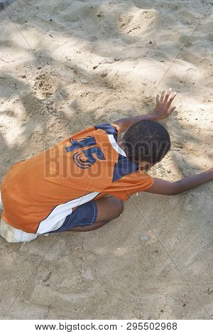 Summer Camper Playing In Sandbox Scraping Up Sand