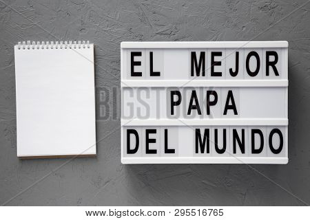 'el Mejor Papa Del Mundo' Words On Lightbox, Blank Notepad Over Gray Background. Overhead, From Abov