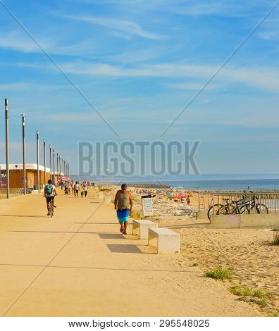 Costa Da Caparica, Lisbon, Portugal - September 17, 2018: People Walking By Seaside Promenade In The