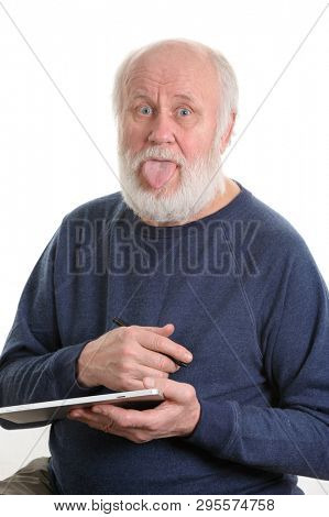Funny bald and bearded senior man with tongue sticking out using tablet computer, isolated on white