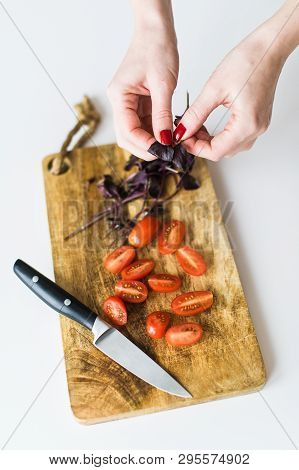 The Chef Tears Off The Leaves Of Basalica. Top View, White Background