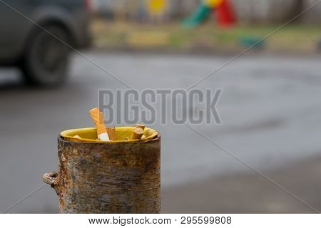 Cigarette Butts Are Stored In A Pipe Of A Column Protection For The Parking Which Is About The Road 